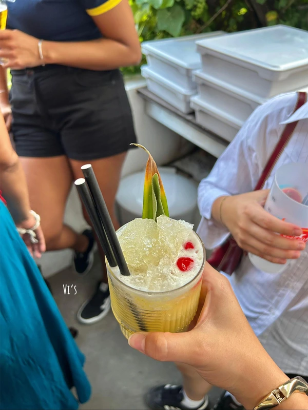 A person holding a refreshing crushed ice cocktail with pineapple garnish at Vi's x Devil's Pie in Lisbon.