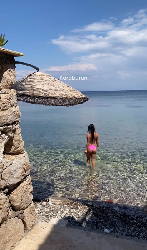A serene and secluded rocky beach with crystal-clear turquoise water on the Karaburun Peninsula in Turkey.