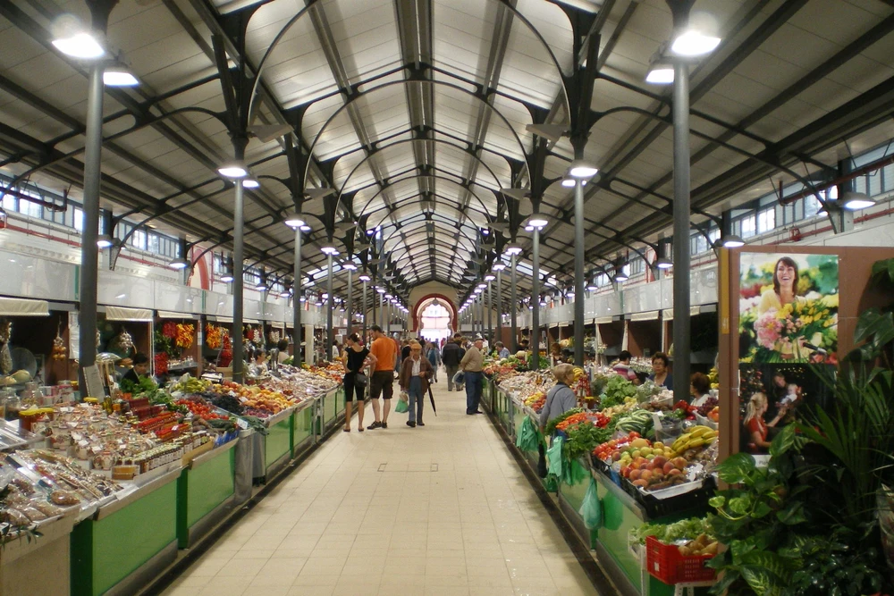 The long, arched interior hall of the Loulé Municipal Market (Mercado Municipal) filled with stalls selling fresh produce, fruits, and vegetables.