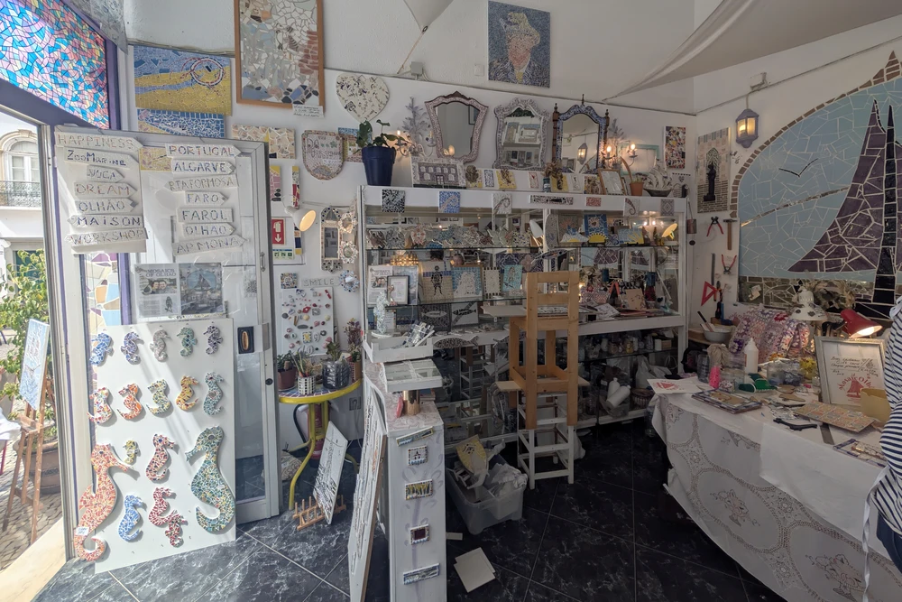 Interior of an artisan shop filled with local mosaic art, handmade gifts, and colorful souvenirs from Olhao, Portugal.