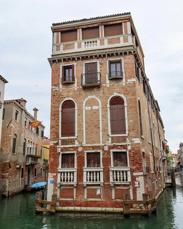 The historic brick Palazzo Tetta in Venice, a unique building surrounded by canals on three sides.