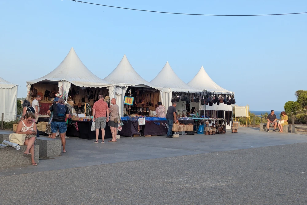 Market stalls near the Praia da Rocha cliffside viewpoint selling leather goods and souvenirs