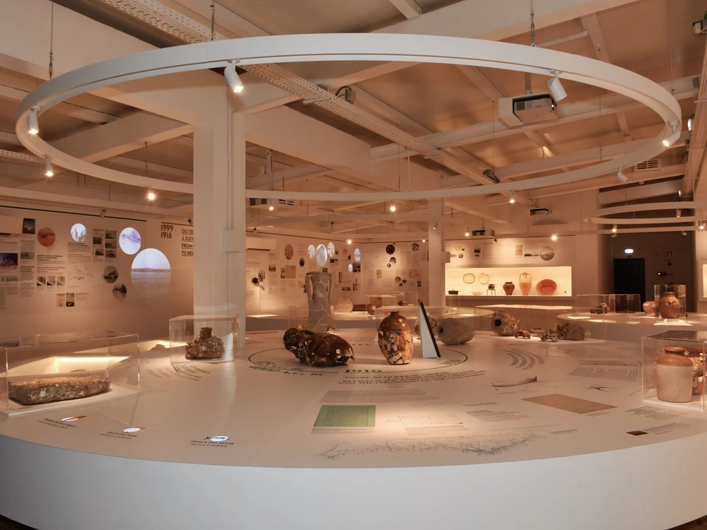 A modern circular display of ancient Roman artifacts at the history museum in Quarteira.
