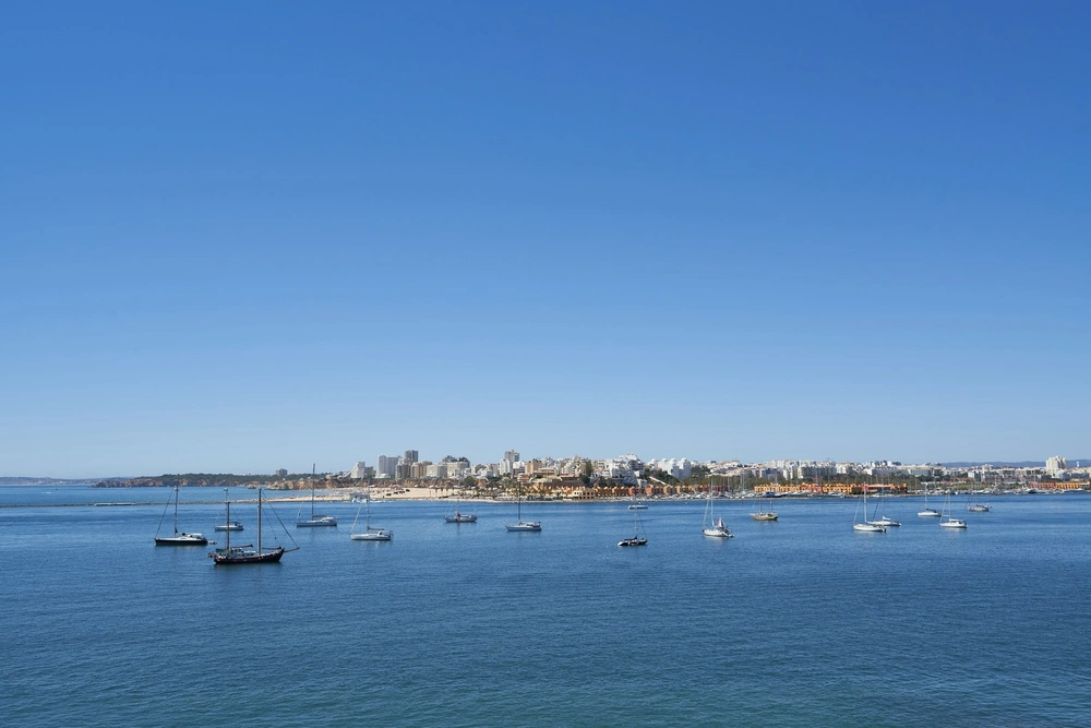 View of boats docked near Praia Da Rocha beach in Portimao